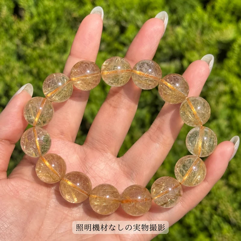 照明機材を使わずに屋外で撮影した、手のひらに載せたゴールドルチルブレスレットの写真