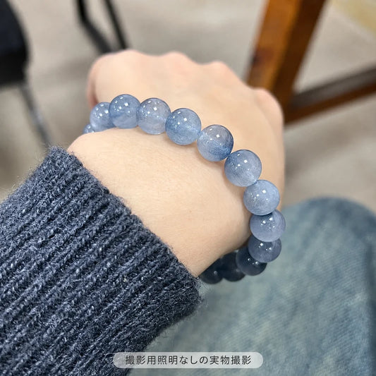 撮影用照明を使わずに撮影した、濃いグレーのニットに合わせたブルーラビットヘアブレスレットの着用写真