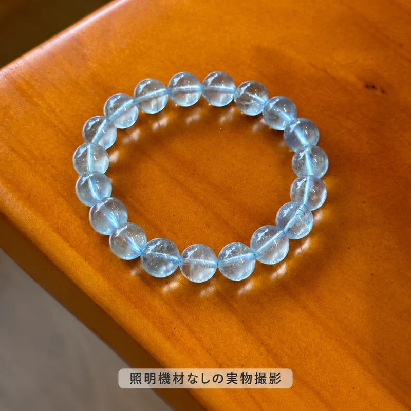 照明機材を使わずに撮影した、木製の台に置いたブルートパーズブレスレットの全体写真