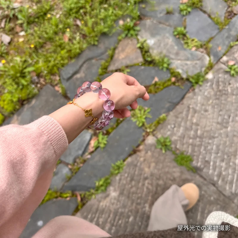 石畳の道でピンクの袖口に合わせたボリビアアメジストブレスレット。屋外光で撮影した着用写真