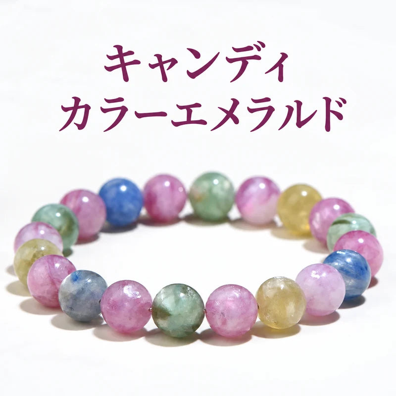 白い背景に置いた、ピンク・青・緑・黄色などの丸玉を組み合わせたキャンディカラーエメラルドブレスレット