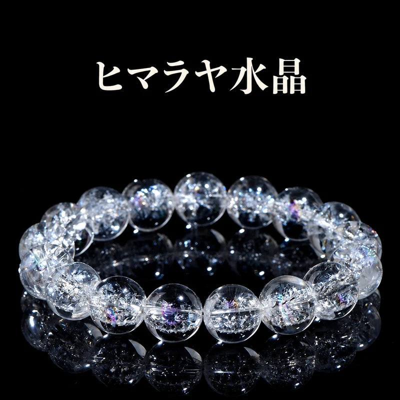 黒い背景に置いた、内部のクラックと虹色の輝きが見えるヒマラヤ水晶の丸玉ブレスレット