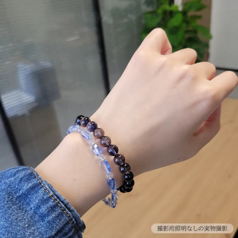 撮影用照明を使わずに撮影した、アイオライトブレスレットを淡い青色のブレスレットと重ねて着けた写真