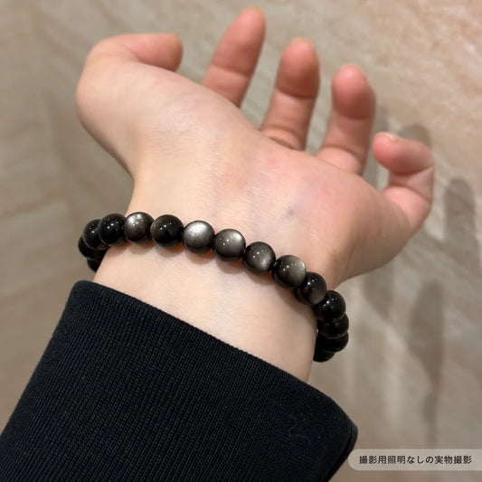 撮影用照明を使わずに撮影した、黒い袖に合わせて手首に着けたオブシディアンブレスレットの写真