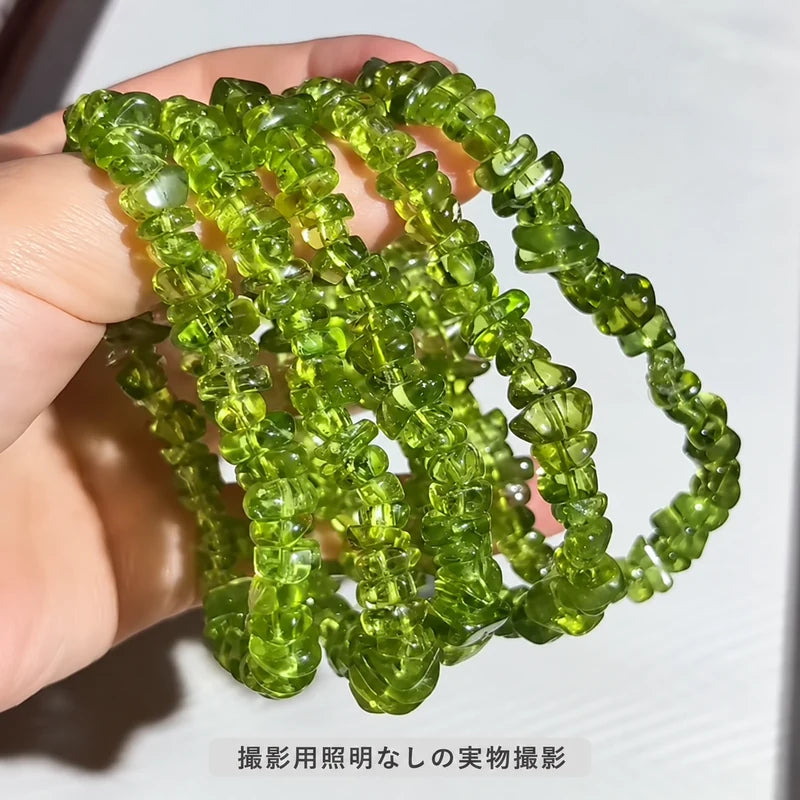 撮影用照明を使わずに撮影した、手に複数本掛けたペリドットさざれ石ブレスレット