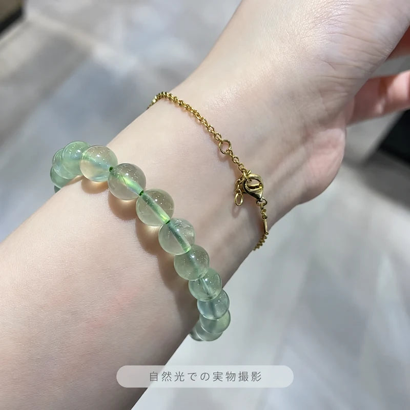 自然光で撮影した、ゴールドカラーのチェーンと重ね着けしたプレナイトブレスレット