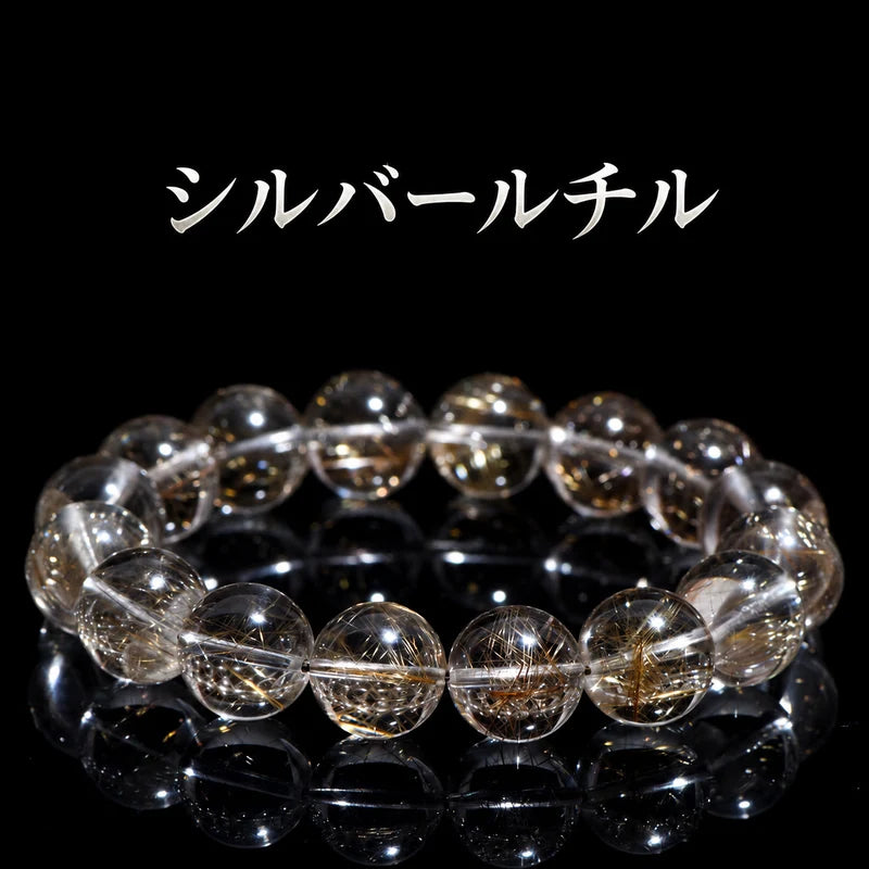 黒い背景に置いた、針状の内包物が見えるシルバールチルの丸玉ブレスレット