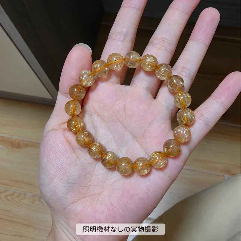 照明機材を使わずに撮影した、手のひらに広げたゴールドルチルブレスレットの全体写真