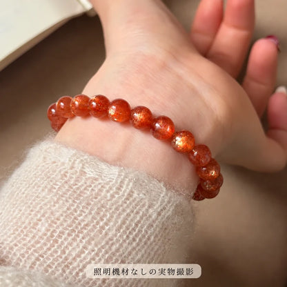 照明機材を使わずに撮影した、淡い色のニットに合わせて手首に着けたゴールドサンストーンブレスレット