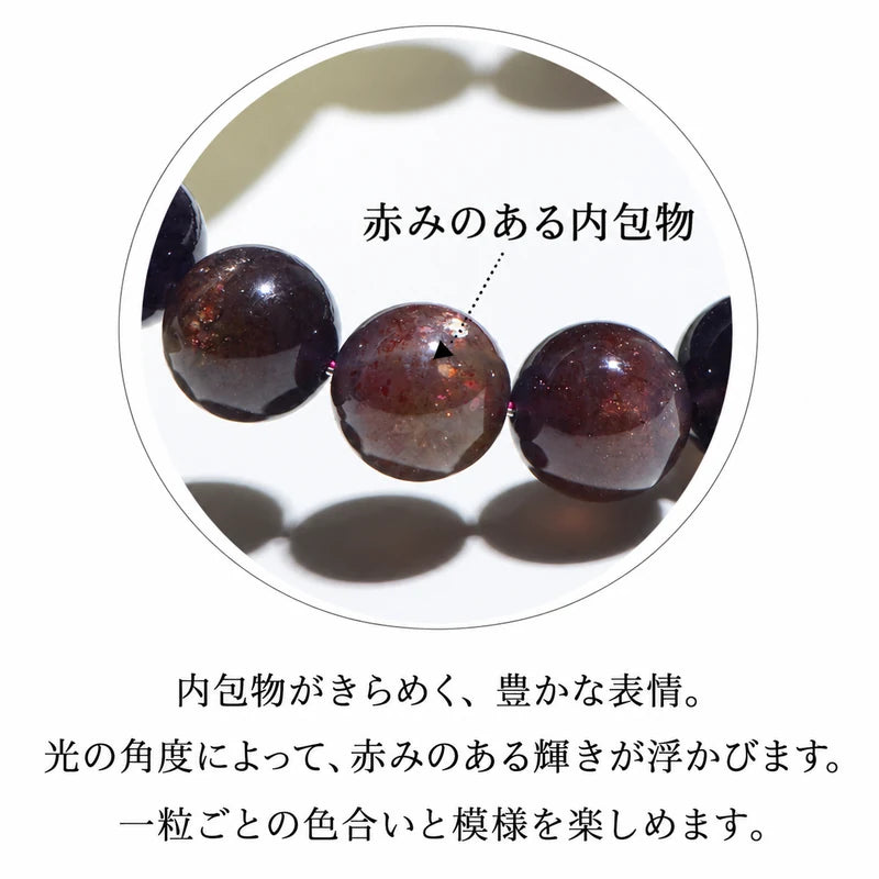アイオライトの珠に見られる、赤みのある内包物と光の反射を示す拡大写真