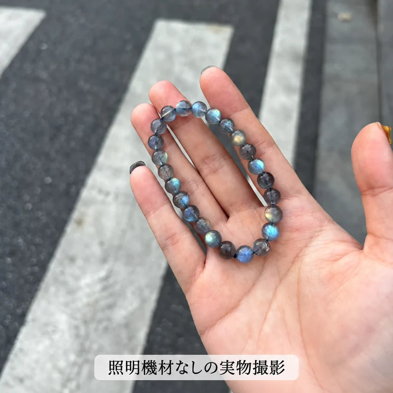 照明機材を使わずに屋外で撮影した、手のひらに載せたラブラドライトブレスレットの全体写真