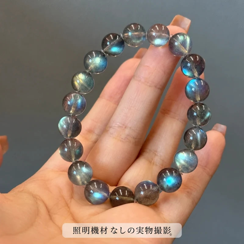 照明機材を使わずに撮影した、手のひらに載せたラブラドライトブレスレットの青や緑の輝きが見える写真
