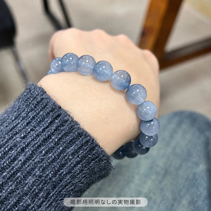撮影用照明を使わずに撮影した、濃いグレーのニットに合わせたブルーラビットヘアブレスレットの着用写真