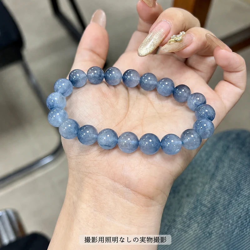 撮影用照明を使わずに撮影した、手のひらに載せたブルーラビットヘアブレスレットの青い丸玉を写した写真