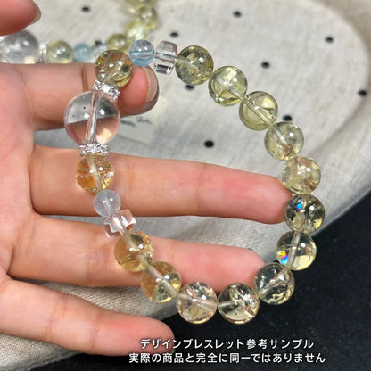 淡い黄色の丸玉に透明なビーズと装飾パーツを組み合わせたデザインブレスレットの参考サンプル。実際の商品とは異なる場合があります。