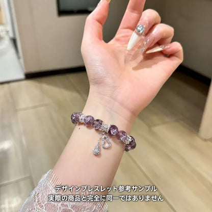 紫色の丸玉にシルバーカラーのハートとしずく形チャームを添えたブレスレットの着用参考サンプル。実際の商品とは異なる場合があります。