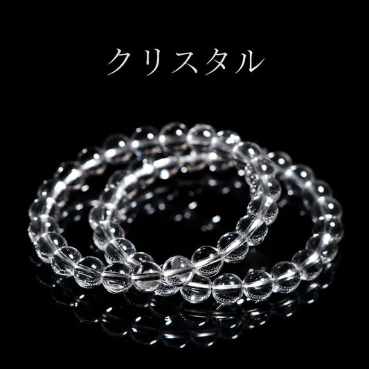 黒い背景に二本重ねて置いた、透明な丸玉のクリスタルブレスレットと「クリスタル」のタイトル