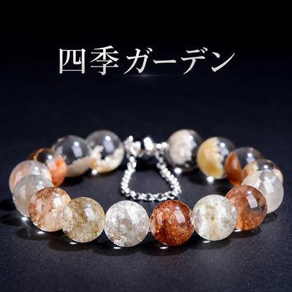 黒い背景に置いた、色とりどりの内包物とシルバーカラーの留め具が見える四季ガーデンブレスレット