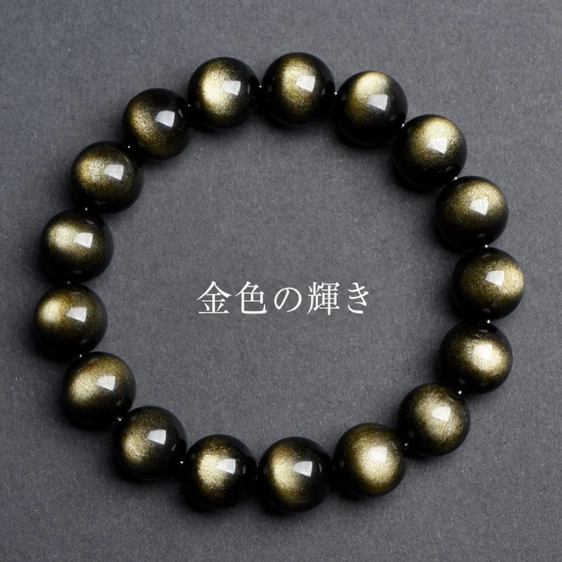 黒い背景で金色の光沢が浮かぶゴールデンオブシディアンブレスレット