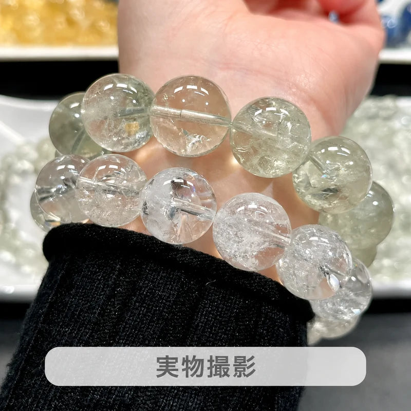 黒い袖口の手首に重ね着けした、淡い緑色のグリーンアゼツライトと透明な丸玉ブレスレットの実物写真