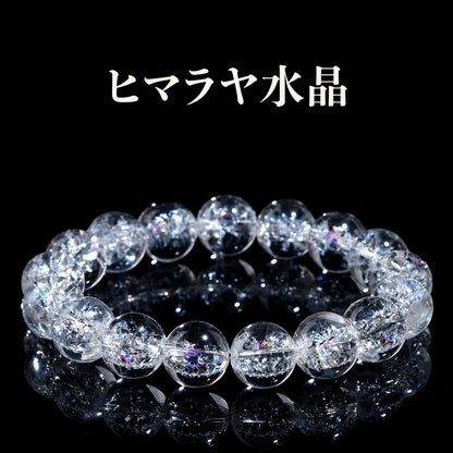 黒い背景に置いた、内部のクラックと虹色の輝きが見えるヒマラヤ水晶の丸玉ブレスレット