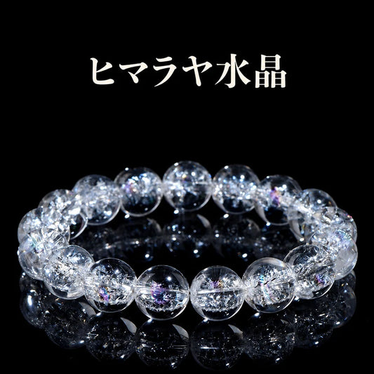 黒い背景に置いた、内部のクラックと虹色の輝きが見えるヒマラヤ水晶の丸玉ブレスレット
