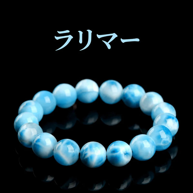 黒い背景に置いた、青と白の波のような模様が見えるラリマーの丸玉ブレスレット