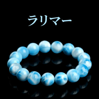 黒い背景に置いた、青と白の波のような模様が見えるラリマーの丸玉ブレスレット