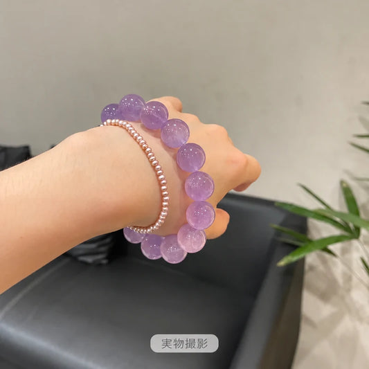 小粒のパールブレスレットと手首に重ね着けした、大粒のラベンダーアメジストブレスレットの実物写真