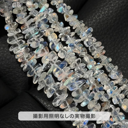 撮影用照明を使わずに撮影した、黒い背景に並べたマダガスカル レインボームーンストーンのさざれ石の連