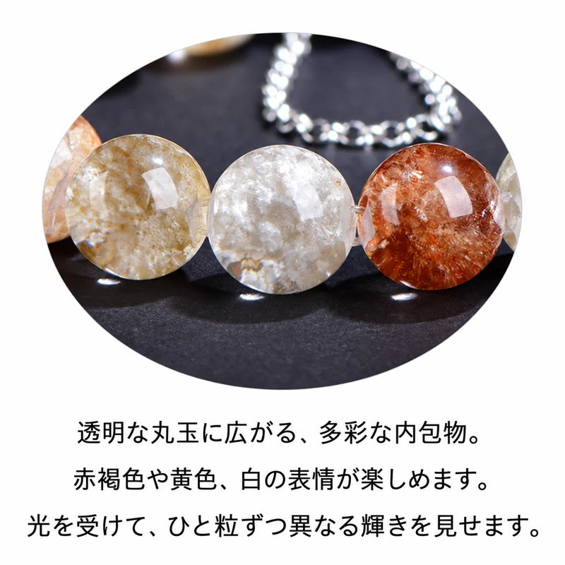 黄色、白、赤褐色の内包物が見える透明な丸玉を拡大した商品説明画像