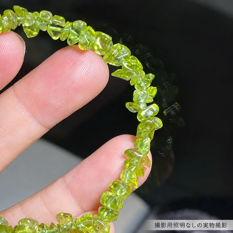 撮影用照明を使わずに撮影した、指に掛けたペリドットさざれ石ブレスレットの石粒と透明感が見える拡大写真