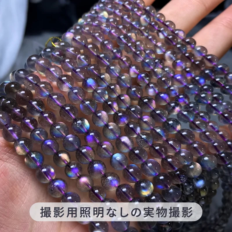 撮影用照明を使わずに撮影した、手のひらに並べた複数のパープルラブラドライトの連ビーズと青紫色の輝き