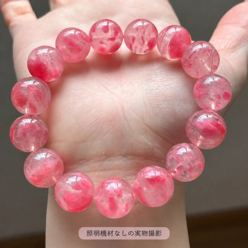 照明機材を使わずに撮影した、手のひらに載せた「桜雨」ブレスレットのピンクの模様が見える拡大写真