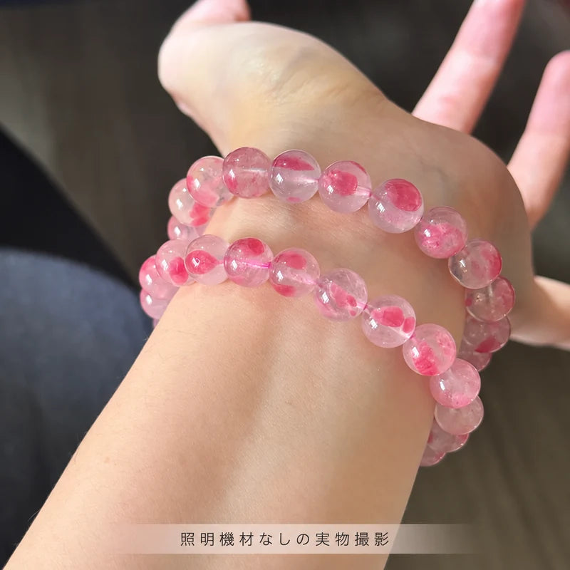 照明機材を使わずに撮影した、手首に二本重ねて着けた「桜雨」のピンクの丸玉ブレスレット