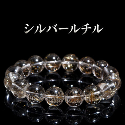 黒い背景に置いた、針状の内包物が見えるシルバールチルの丸玉ブレスレット