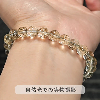 自然光で撮影した、手首に着けたゴールドルチルクォーツの丸玉ブレスレット