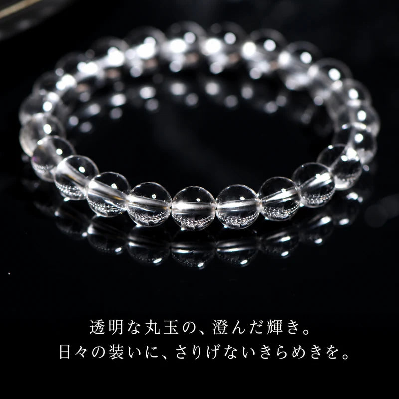 黒い光沢のある台に置いた透明な丸玉ブレスレットと日本語の説明