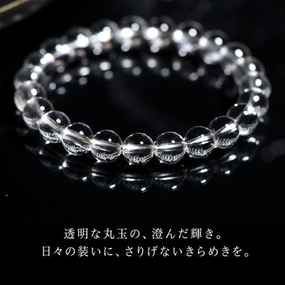 黒い光沢のある台に置いた透明な丸玉ブレスレットと日本語の説明