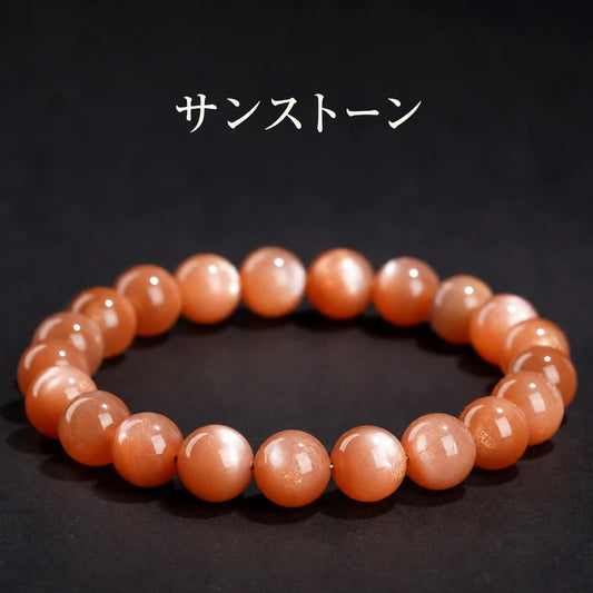 サンストーンの丸玉ブレスレット。黒い背景にオレンジ色の珠と金色の細かなきらめきが見える全体写真