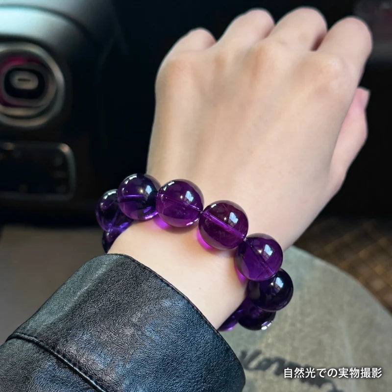 黒いレザーの袖口に合わせたウルグアイアメジストブレスレット。車内の自然光で丸玉を写した着用写真