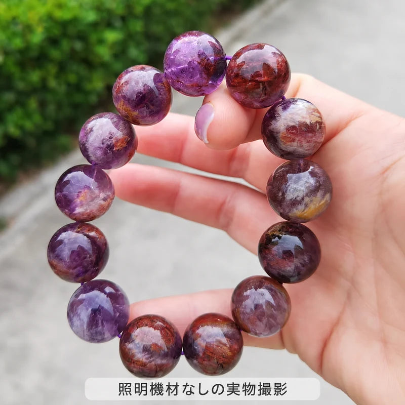 照明機材を使わずに撮影した、手に持ったパープルファントムクォーツブレスレットの実物写真